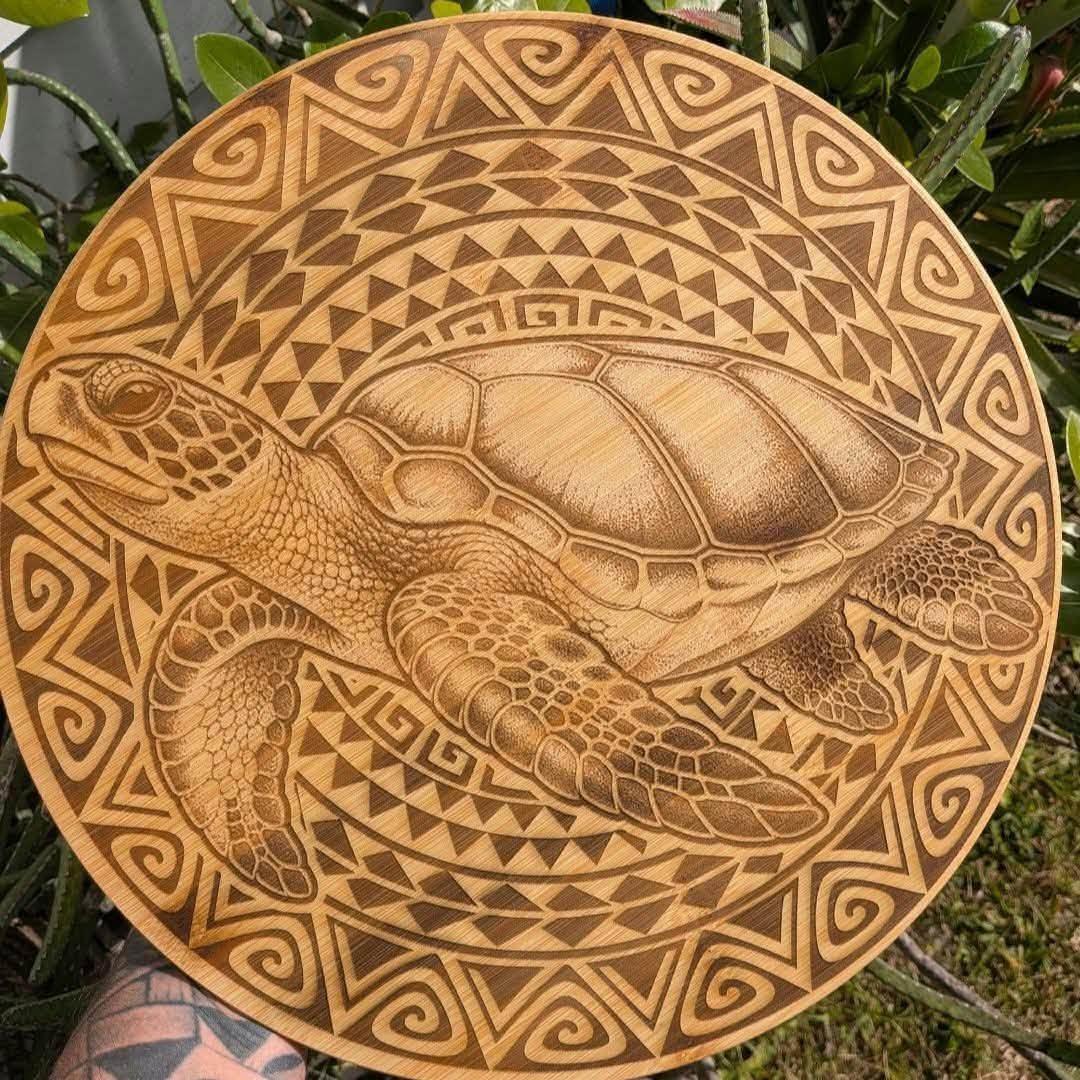 Planche ronde en bambou gravée d'une tortue et de motifs polynésiens
